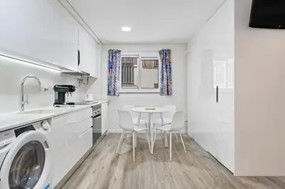a kitchen with a washing machine and a table at Studio Carmo in Funchal