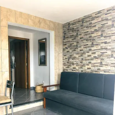 a living room with a blue couch and a brick wall at Brisas da Raposeira in Raposeira