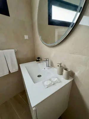 a bathroom with a white sink and a mirror at Calheta Nest in Calheta