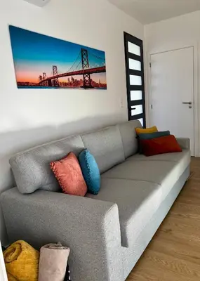 a living room with a gray couch with colorful pillows at Calheta Nest in Calheta