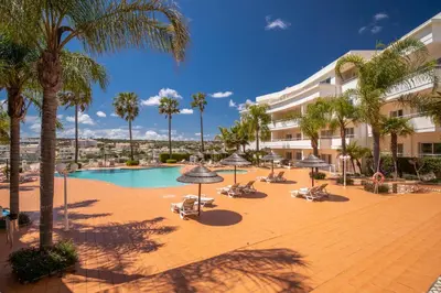 a resort with a pool and palm trees and buildings at Orange Beach Ocean View, Porto de Mós VR29 in Lagos