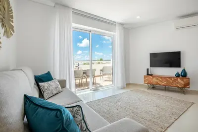 a living room with a couch and a flat screen tv at Orange Beach Ocean View, Porto de Mós VR29 in Lagos