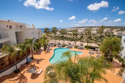 an aerial view of a resort with a pool and palm trees at Orange Beach Ocean View, Porto de Mós VR29 in Lagos