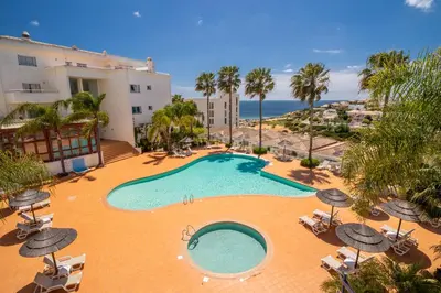 an image of a swimming pool with umbrellas and the ocean at Blue Beach Ocean View, Porto de Mós VR14 in Lagos