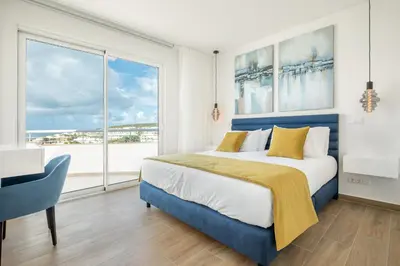 a bedroom with a blue bed and a large window at Blue Beach Ocean View, Porto de Mós VR14 in Lagos