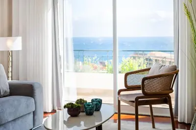 a living room with a couch and a table in front of a window at Exquisite Ocean Apartment by Homie in Caniço