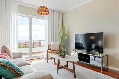 a living room with a couch and a tv at Exquisite Ocean Apartment by Homie in Caniço