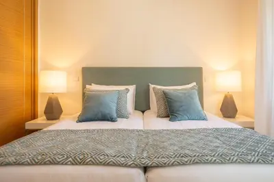 a bedroom with a large bed with blue pillows at Yellow Beach Ocean View, Porto de Mós VR38 in Lagos