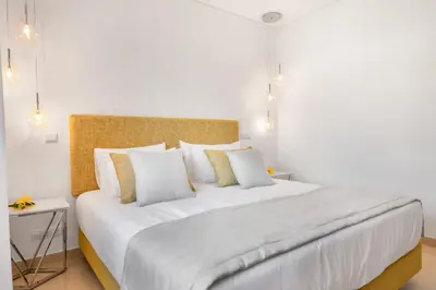 a bedroom with a large white bed with white and yellow pillows at Yellow Beach Ocean View, Porto de Mós VR38 in Lagos