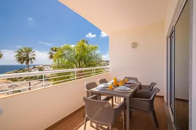 a balcony with a table and chairs and the ocean at Yellow Beach Ocean View, Porto de Mós VR38 in Lagos