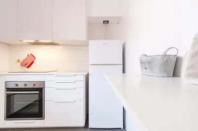 a kitchen with white appliances and a white counter top at GuestReady - Marvellous ocean view in Caniço in Caniço