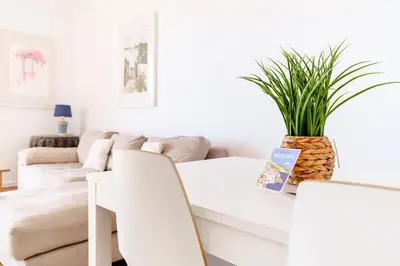 a white living room with a white table and chairs at GuestReady - Marvellous ocean view in Caniço in Caniço