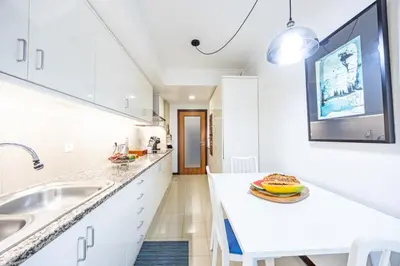 a white kitchen with a sink and a counter at Ocean Lido in Funchal