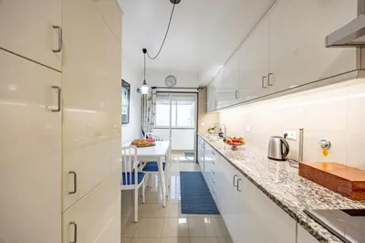 a kitchen with white cabinets and a counter top at Ocean Lido in Funchal