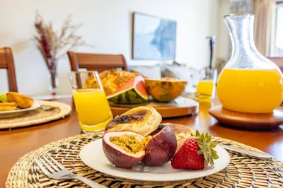 a table with a plate of fruit and a jug of orange juice at Ocean Lido in Funchal