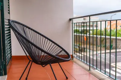 a black chair sitting on a balcony with a view at GuestReady - Peaceful getaway near the beach in Machico