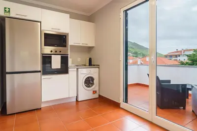 a kitchen with a washer and dryer at GuestReady - Peaceful getaway near the beach in Machico
