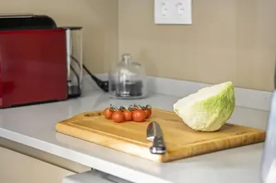 a cutting board with tomatoes and a block of iceberg lettuce at Cozy Apartments by Homie in Porto Moniz