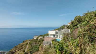 a house on a cliff next to the ocean at Villa Althea by YMR in Calheta