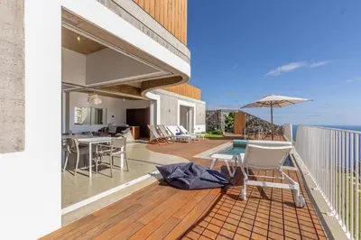 a bedroom with a bed with a view of the ocean at Terraços da Calheta by YMR in Estreito da Calheta