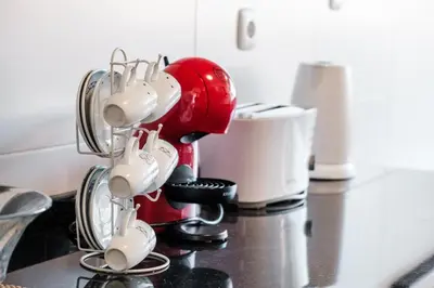 a red mixer sitting on top of a kitchen counter at GuestReady - Sea breeze in Funchal in Funchal