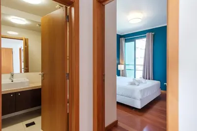 a bedroom with a bed and a bathroom with a tub at GuestReady - Sea breeze in Funchal in Funchal