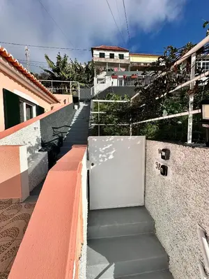 a door on the side of a building with stairs at Little Blue Paradise in Ribeira Brava