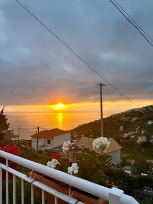 a view of a sunset from the balcony of a house at Little Blue Paradise in Ribeira Brava