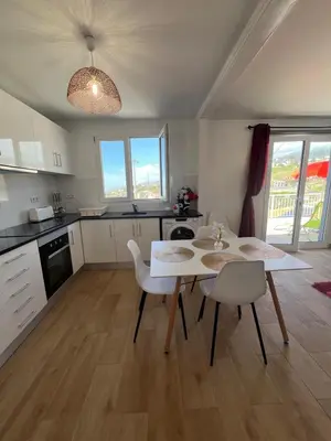 a kitchen with a table and chairs in a room at Little Blue Paradise in Ribeira Brava