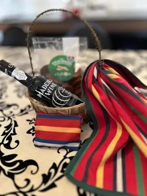 a bottle of wine in a basket next to a scarf at Apartamento Batista in Funchal