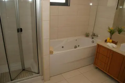 a bathroom with a shower and a tub and a sink at Apartamento Batista in Funchal