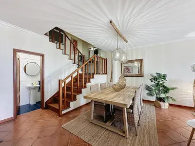 a dining room with a table and a staircase at Ocean View Botânico in Funchal