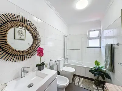a bathroom with a sink and a toilet and a mirror at Ocean View Botânico in Funchal