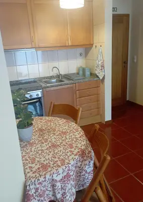 a kitchen with a table and chairs and a sink at Village Sun House - Porto Moniz in Porto Moniz