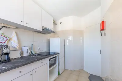 a kitchen with white cabinets and a refrigerator at Funchal pad with Harbor Views & cool Aircon Bliss in Funchal