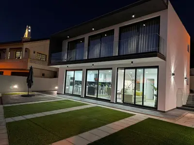 a house with large windows and a lawn at night at Bela Vista Funchal Villa in Funchal