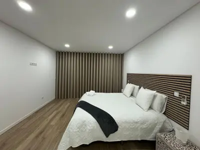 a bedroom with a large bed with white sheets at Bela Vista Funchal Villa in Funchal