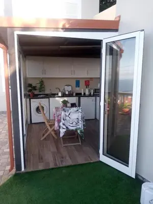 a kitchen with an open door to a patio with a table at La terraza de Ponta do Sol -Suite 1 in Ponta do Sol