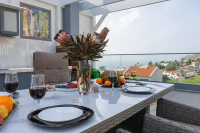 a balcony with a view of a city at night at VILLA HELENA Crystal Apartment in Caniço