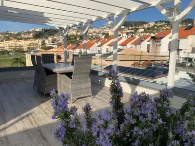 a balcony with a view of a city at night at VILLA HELENA Crystal Apartment in Caniço