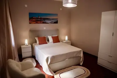 a bedroom with a bed and a chair at Faria's House 2 in Feiteiras