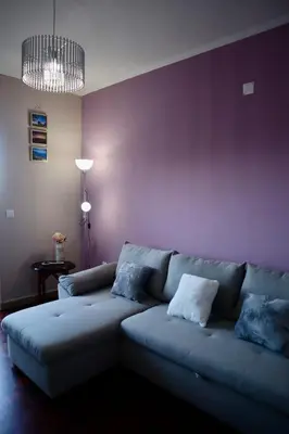 a living room with a couch and a purple wall at Faria's House 2 in Feiteiras