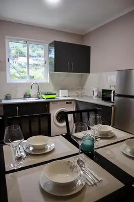a kitchen with a table with plates and wine glasses at Faria's House 2 in Feiteiras