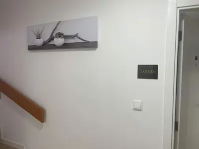 a white wall with a shelf with two vases on it at CGD São Vicente Apartments in São Vicente
