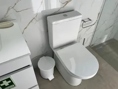 a white bathroom with a toilet and a sink at CGD São Vicente Apartments in São Vicente
