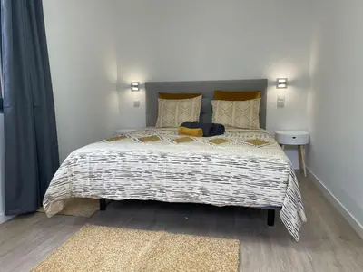 a bedroom with a large bed with a blanket at CGD São Vicente Apartments in São Vicente
