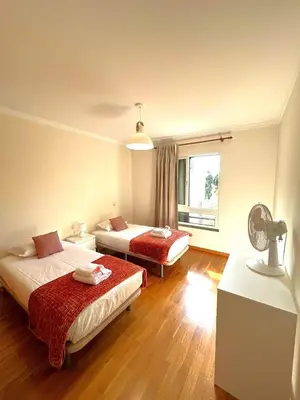 a hotel room with two beds and a fan at Suite Elizabeth in Funchal