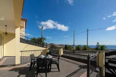 a table and chairs on a balcony with a view of the ocean at Casa Jorge Calaça by An Island Apart in Caniçal