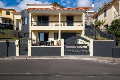 a yellow house with a balcony with a table at Casa Jorge Calaça by An Island Apart in Caniçal
