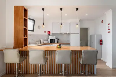 a kitchen with a wooden counter and chairs in it at Casa Jorge Calaça by An Island Apart in Caniçal